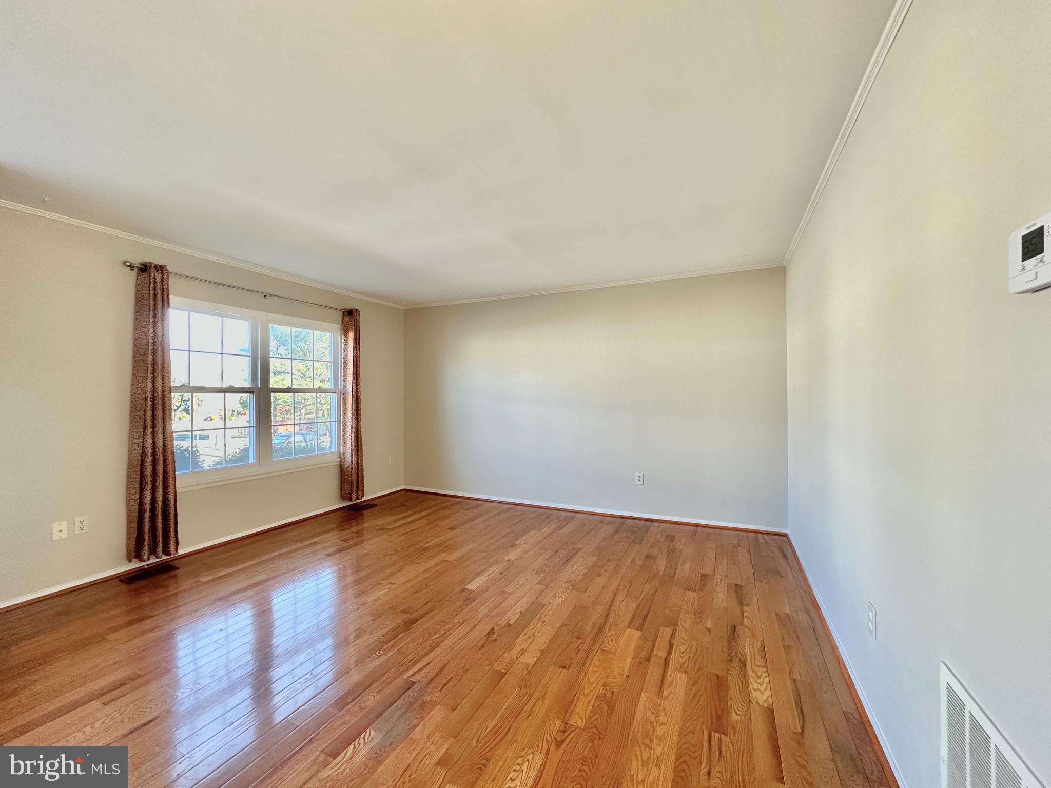 402 Carousel Court Gaithersburg, MD 20877 - Photo 5 of 29 a view of an empty room with wooden floor and a window