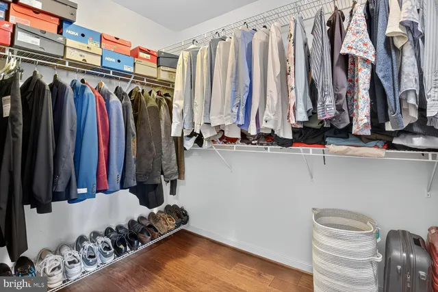 a view of walk in closet with clothes and shoes