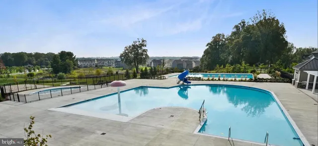 a view of a swimming pool with a patio and a garden