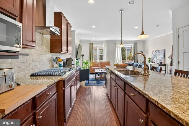 a kitchen with stainless steel appliances granite countertop sink stove top oven and cabinets
