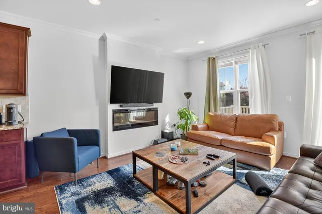a living room with furniture a flat screen tv and a window