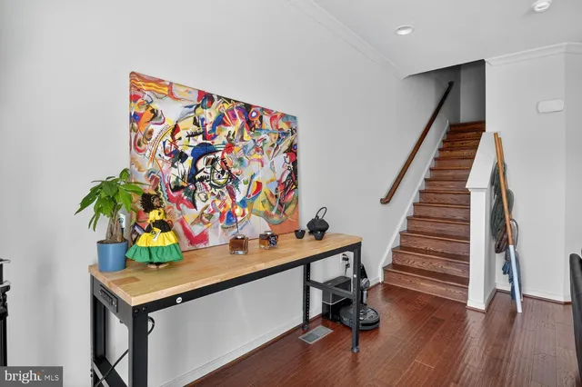 a view of a room with gym equipment and wooden floor