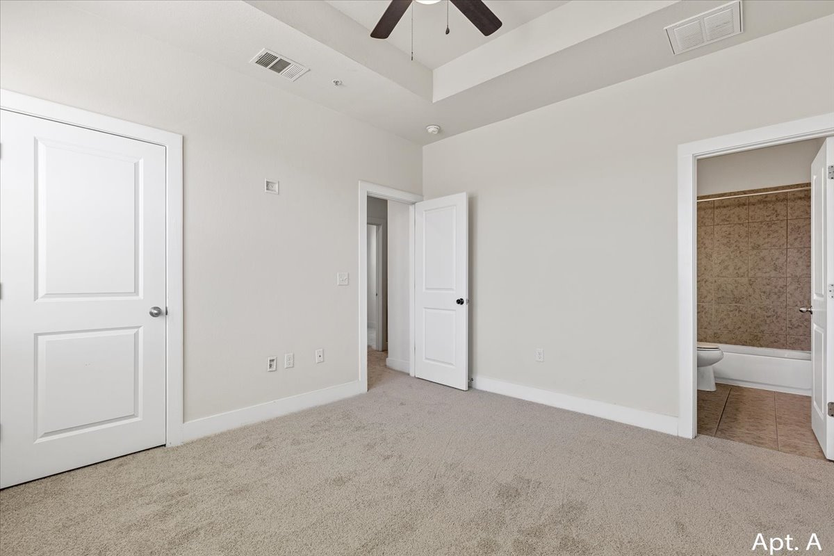 2225 Katy Lane, Unit A Georgetown, TX 78626 - Photo 16 of 22 Unfurnished bedroom featuring new carpet, ceiling fan, and ensuite bath