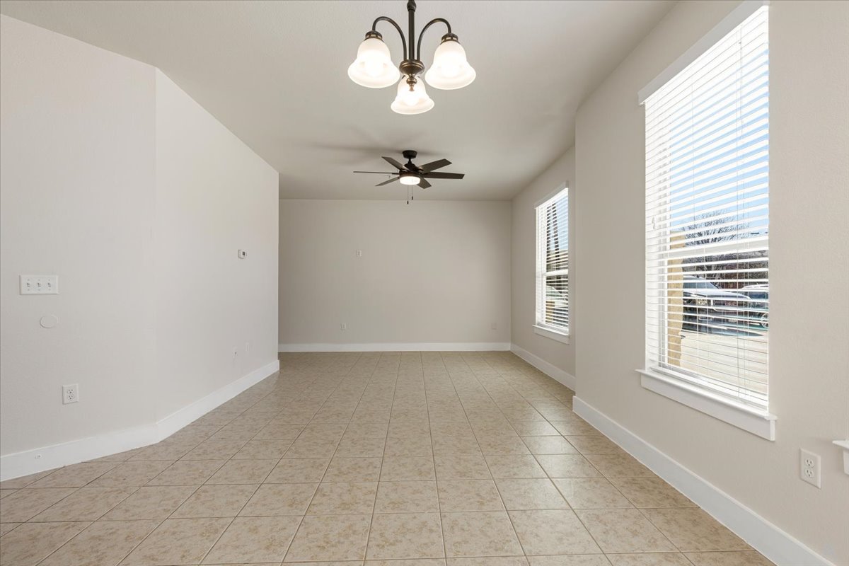 2225 Katy Lane, Unit A Georgetown, TX 78626 - Photo 7 of 22 Spare room with a ceiling fan, hanging lights, and light tile patterned flooring
