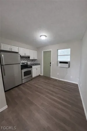 a view of a kitchen with a sink stove cabinets and empty room