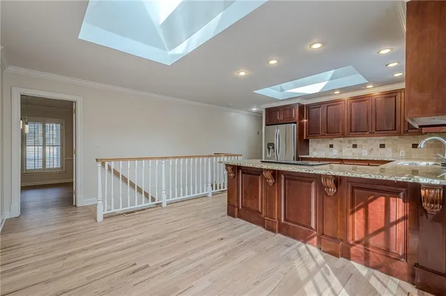 a kitchen with stainless steel appliances granite countertop wooden cabinets a sink and a stove