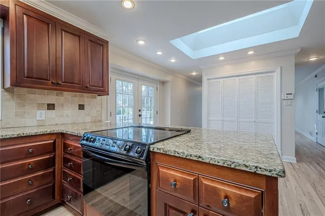 a view of an empty room with wooden floor fireplace and a window