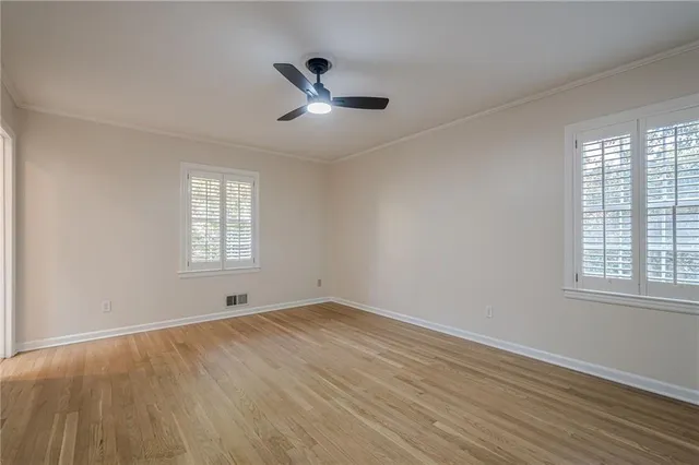 a view of empty room with wooden floor