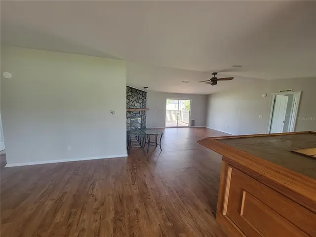 a view of empty room with wooden floor and window