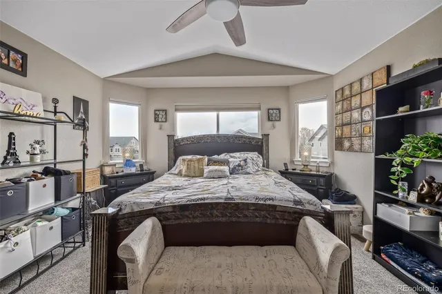 a bedroom with a bed a couch and a potted plant