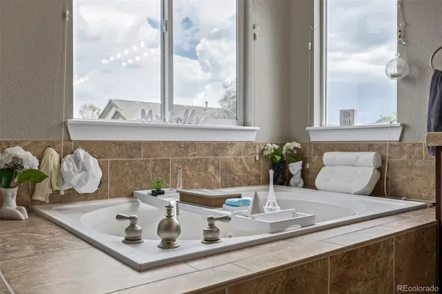 a spacious bathroom with a tub sink and mirror