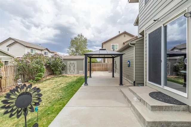 a patio with table and chairs and potted plants