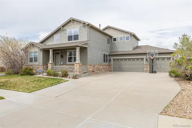 a front view of a house with yard and tress