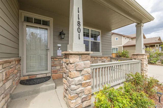 a view of a brick house with large windows and wooden fence
