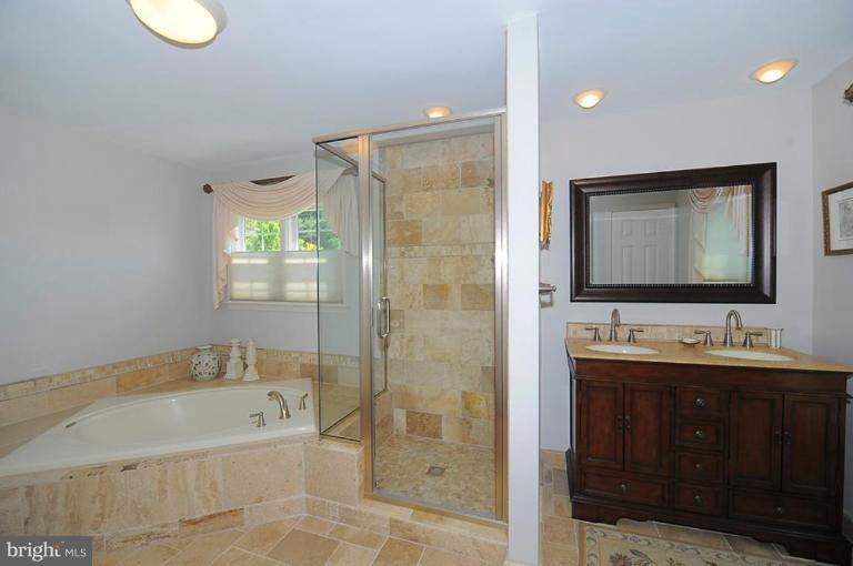 6583 Forsythia Street Springfield, VA 22150 - Photo 13 of 28 a bathroom with a bathtub sink and mirror