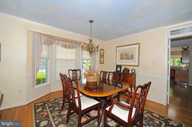 6583 Forsythia Street Springfield, VA 22150 - Photo 3 of 28 a dining room with furniture a chandelier and wooden floor