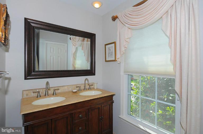 6583 Forsythia Street Springfield, VA 22150 - Photo 24 of 28 a bathroom with a sink a vanity and a mirror