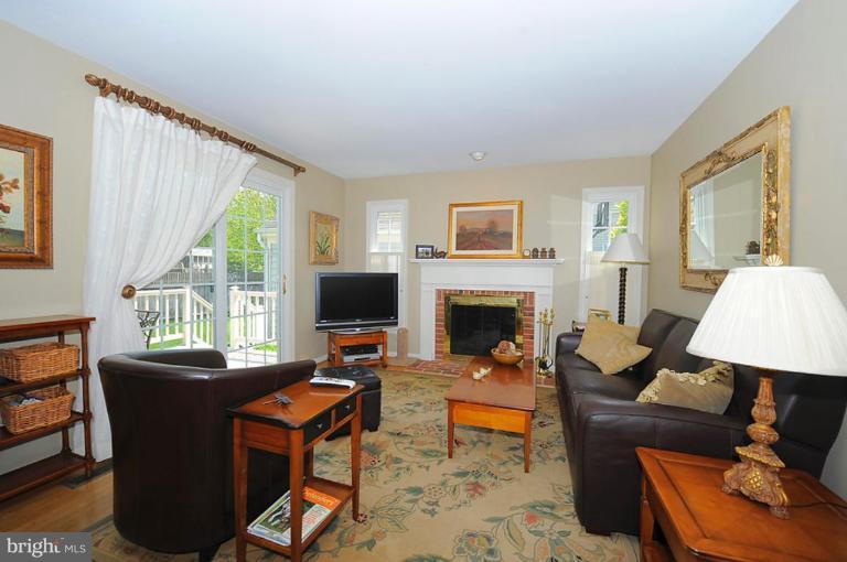 6583 Forsythia Street Springfield, VA 22150 - Photo 5 of 28 a living room with furniture a large window and a fireplace