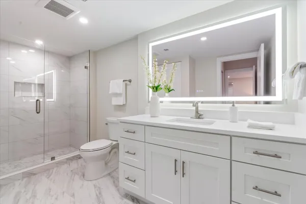 a bathroom with a double vanity sink toilet and shower