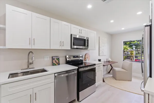 a kitchen with stainless steel appliances granite countertop a sink a stove and a refrigerator