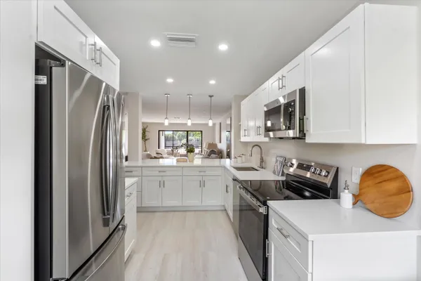 a kitchen with stainless steel appliances granite countertop a refrigerator sink and stove
