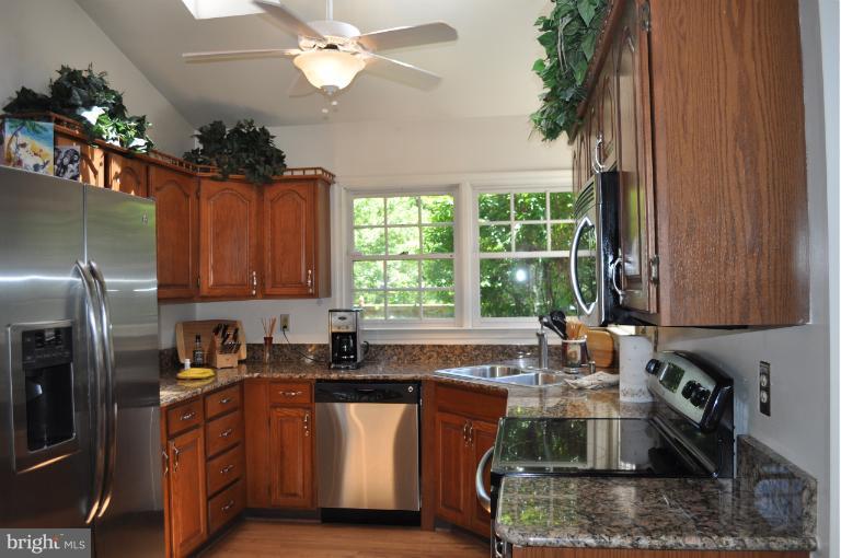 6601 Forsythia Street Springfield, VA 22150 - Photo 2 of 26 a kitchen with stainless steel appliances granite countertop a sink a stove and a refrigerator