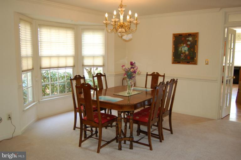 6601 Forsythia Street Springfield, VA 22150 - Photo 14 of 26 a view of a dining room with furniture a chandelier and a window