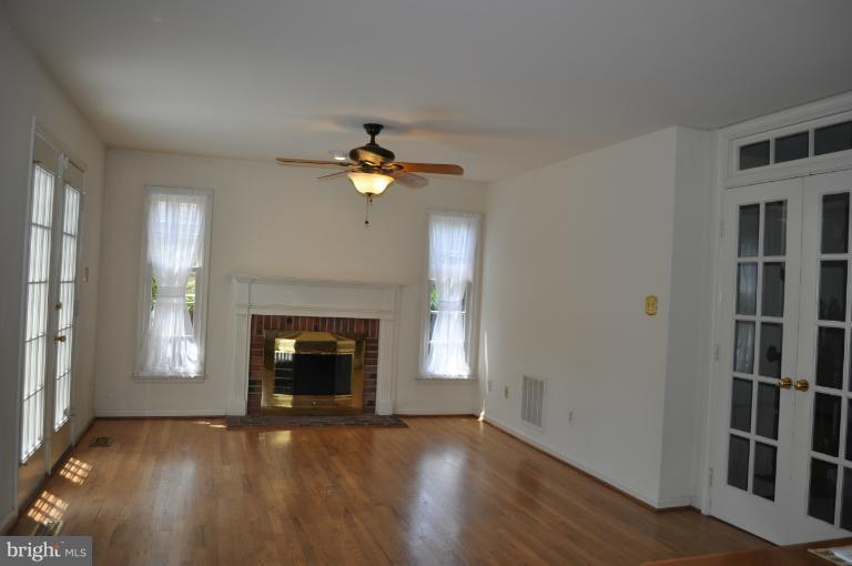 6601 Forsythia Street Springfield, VA 22150 - Photo 6 of 26 an empty room with windows and fireplace