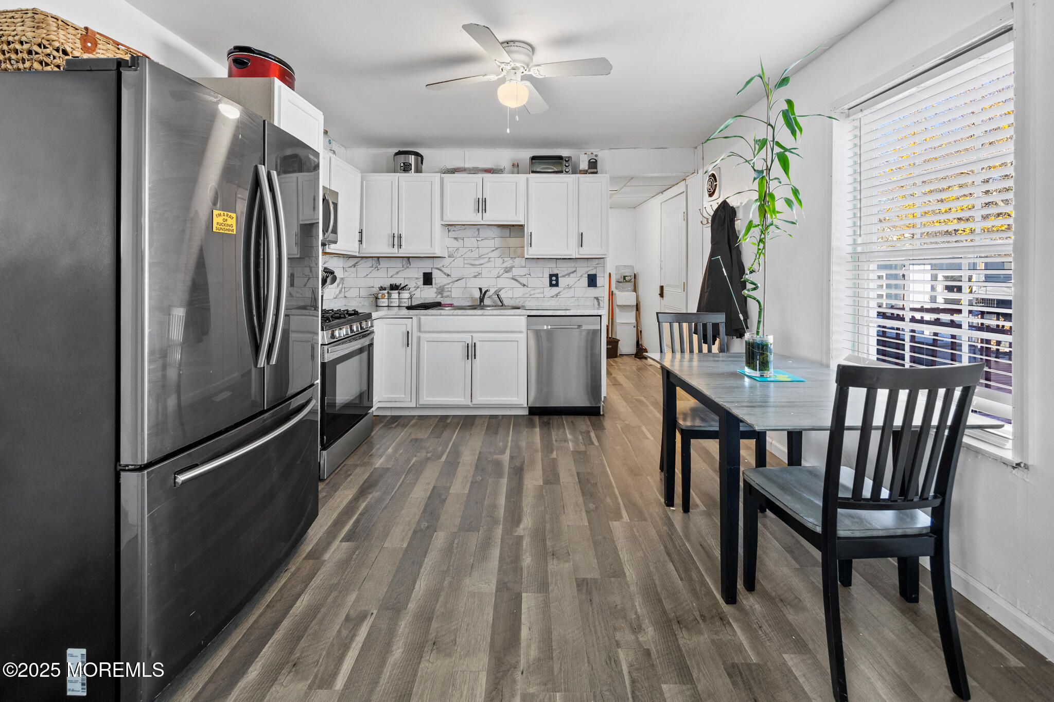 14 Georgetown Boulevard Barnegat, NJ 08005 - Photo 11 of 39 a kitchen with a refrigerator a sink dishwasher a dining table and chairs with wooden floor