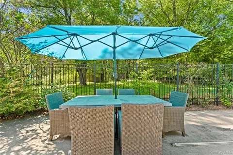 a lawn chairs sitting under a blue umbrella