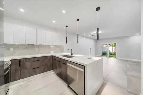 a kitchen with a sink a stove and cabinets