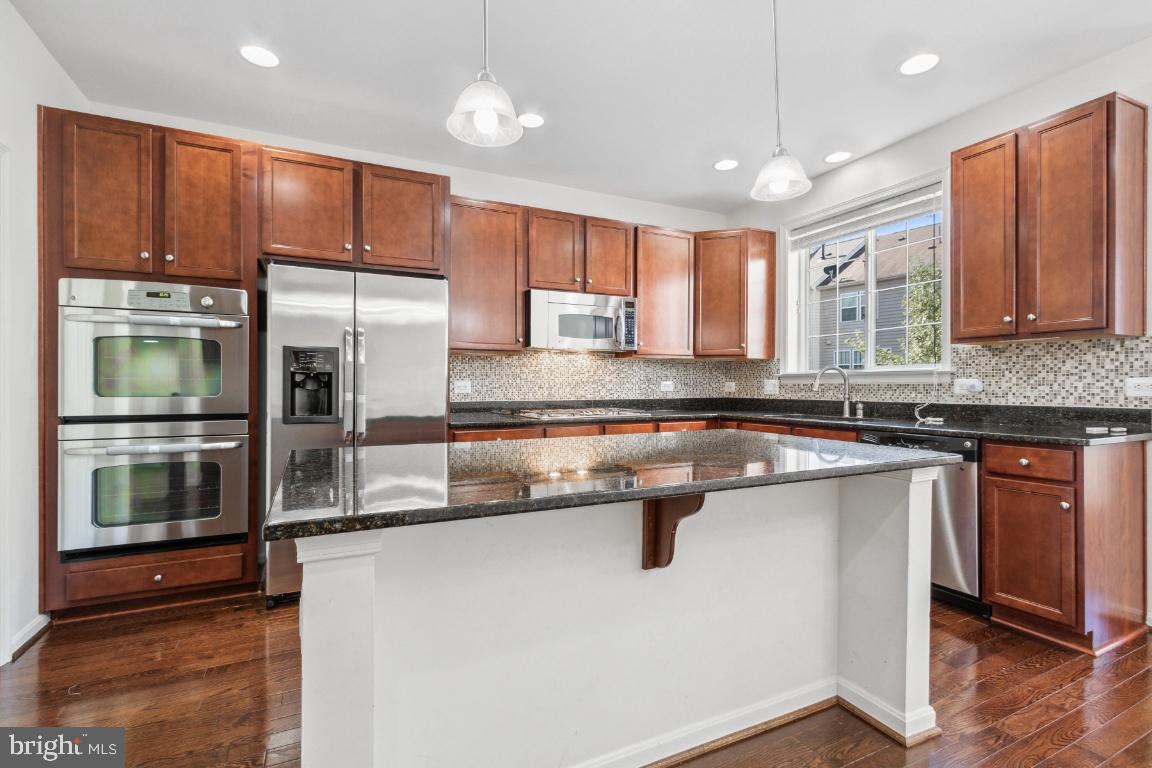 42219 Dean Chapel Square Chantilly, VA 20152 - Photo 6 of 21 a kitchen with stainless steel appliances granite countertop a refrigerator a sink and a stove