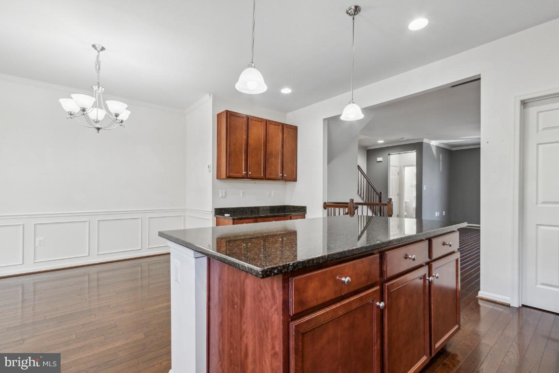 42219 Dean Chapel Square Chantilly, VA 20152 - Photo 7 of 21 a room with stainless steel appliances granite countertop a sink dishwasher a stove a dining table and chairs with wooden floor