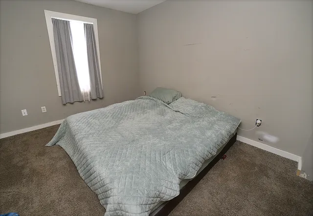 a bed sitting in a bedroom next to a window