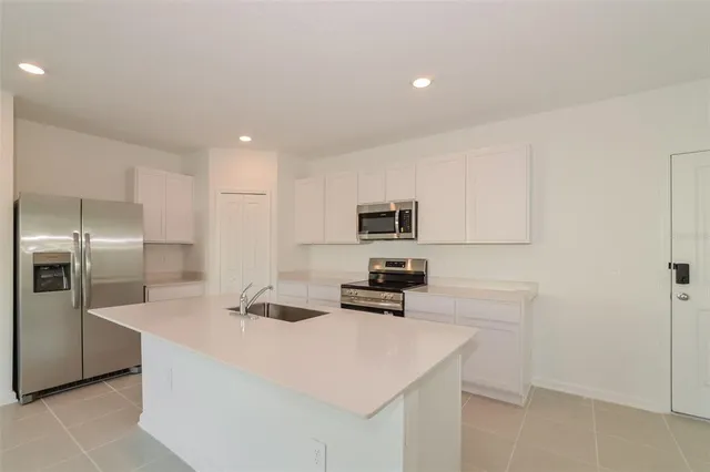 a kitchen with stainless steel appliances a refrigerator sink and stove