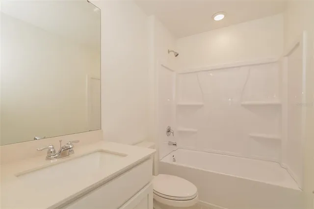 a bathroom with a granite countertop sink a toilet and shower