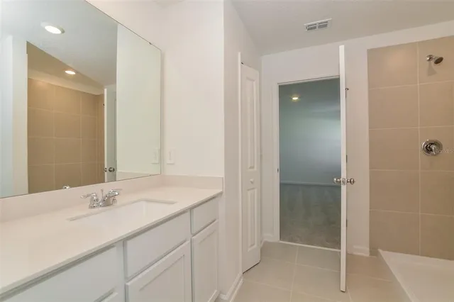 a bathroom with a shower sink and mirror