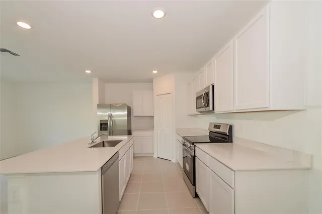 a kitchen with a sink a stove top oven and white kitchen