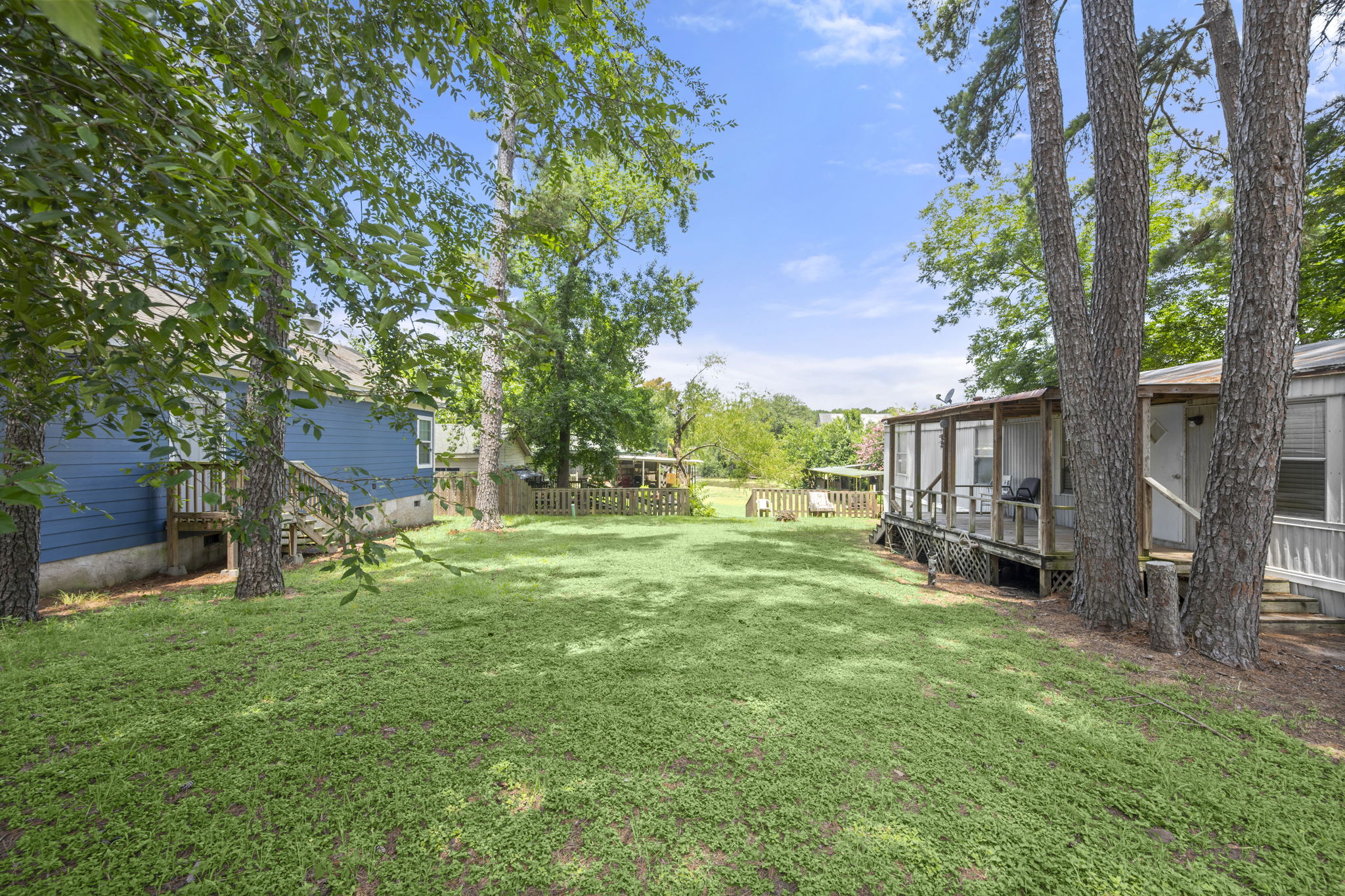 9649 Warm Spring Willis, TX 77318 - Photo 2 of 30 A spacious, verdant yard provides ample outdoor living space.