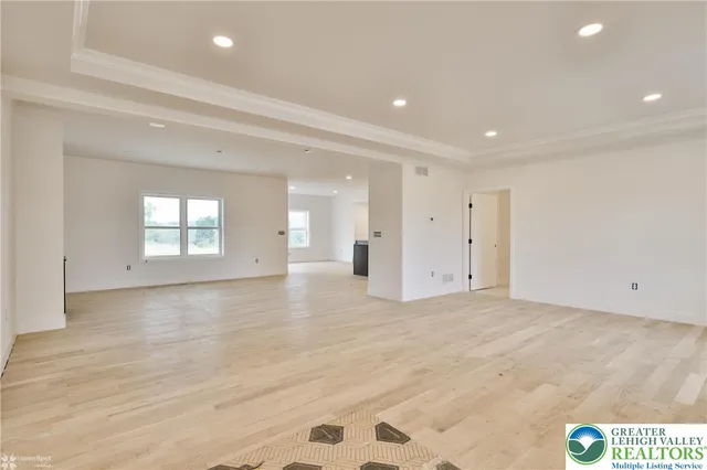 a view of an empty room with wooden floor and a fireplace