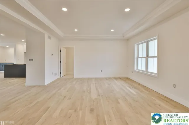 a view of an empty room with a window and a fireplace