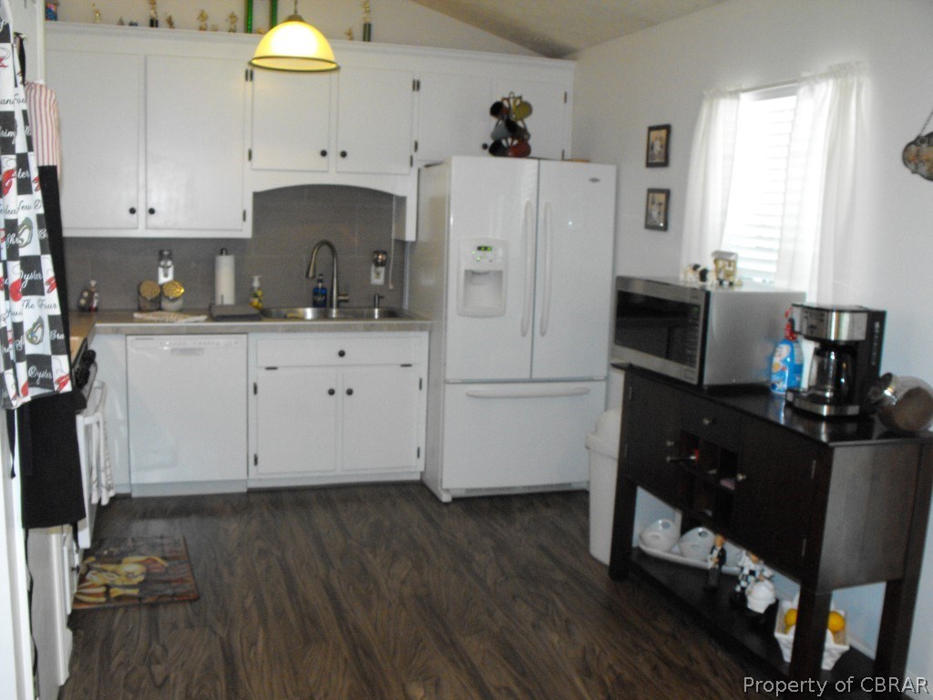 207 Windsor Road Dutton, VA 23050 - Photo 2 of 38 a kitchen with a refrigerator a stove a sink dishwasher and white cabinets with wooden floor