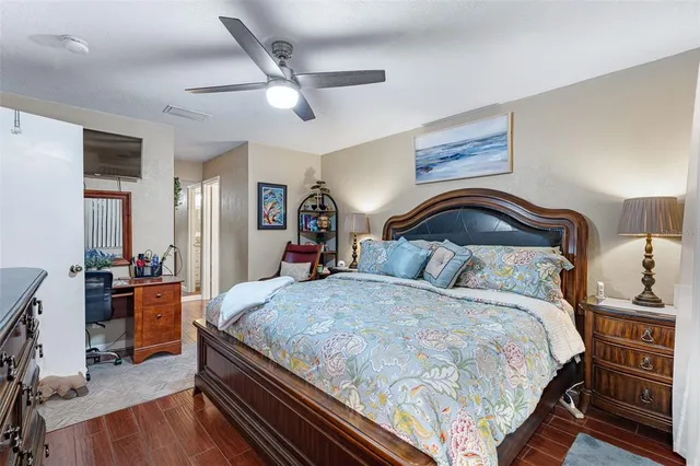 a bedroom with bed and wooden floor