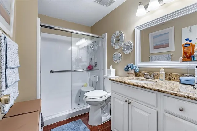 a bathroom with a granite countertop sink mirror vanity and toilet