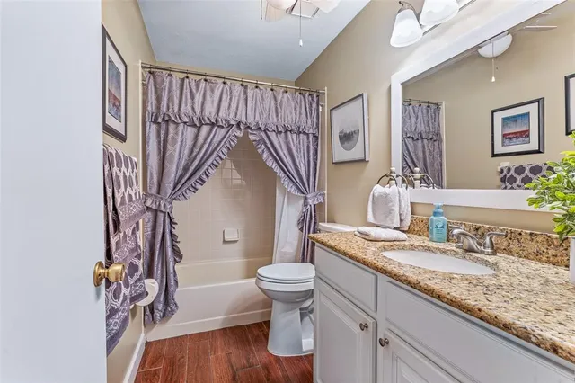 a bathroom with a granite countertop sink a toilet and a mirror