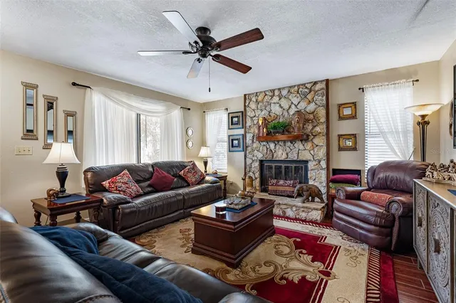 a living room with furniture a large window and a fireplace