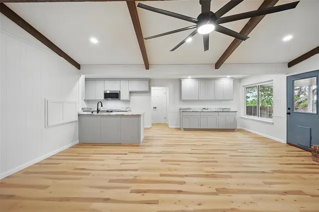 a view of an empty room with a window and cabinet
