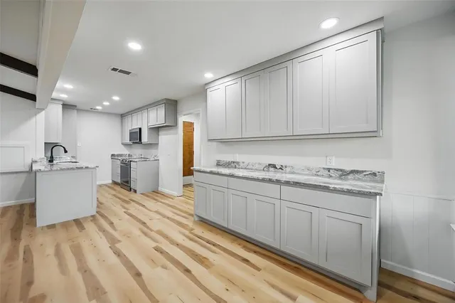 a kitchen with granite countertop cabinets stainless steel appliances and a sink