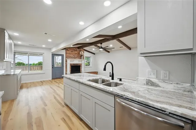 a kitchen with granite countertop a sink and cabinets