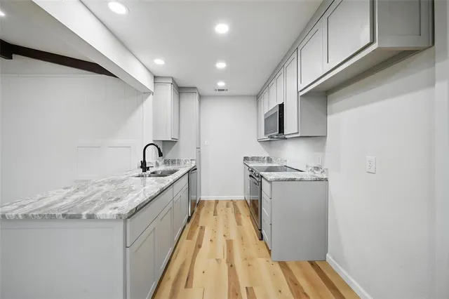 a kitchen with stainless steel appliances granite countertop a sink and wooden cabinets
